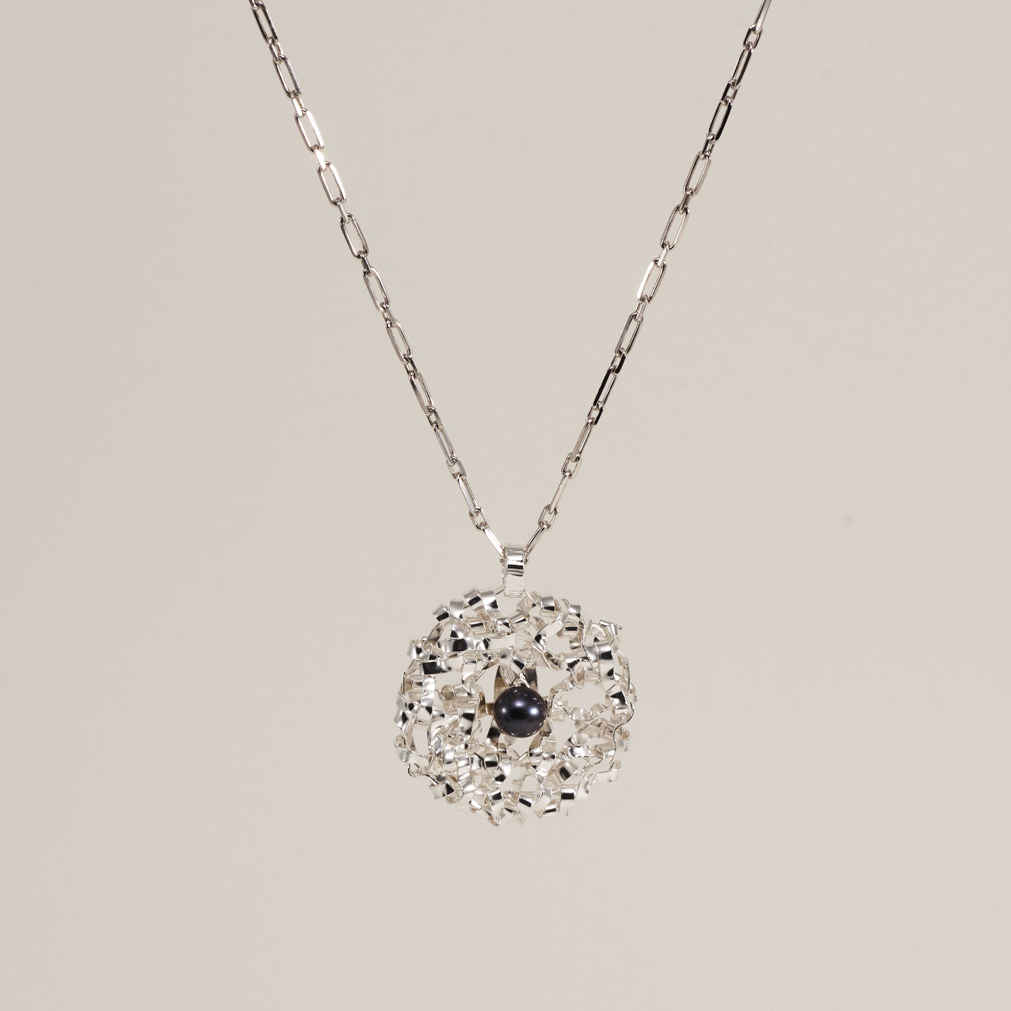 Piccola collana con ciondolo rotondo intrecciato e perla